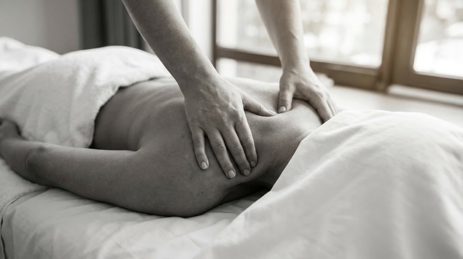 Deep tissue massage therapy, hands applying firm pressure on upper back